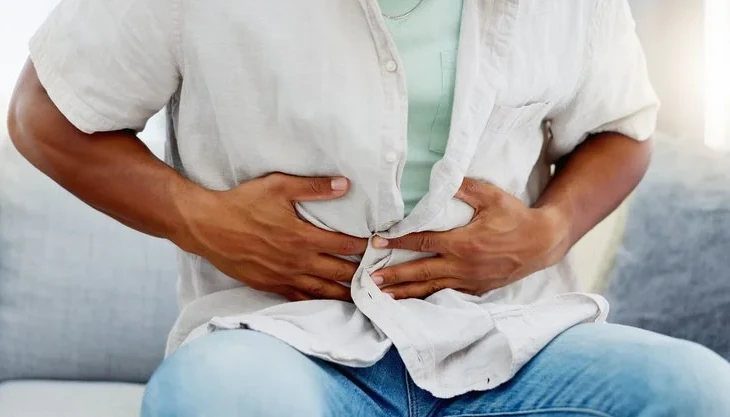 fájó gyomrát fogó férfi