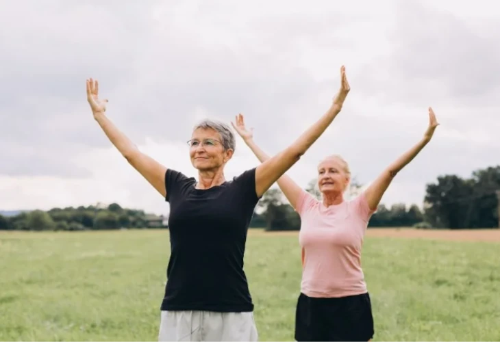 két idősebb hölgy tornázik a szabadban